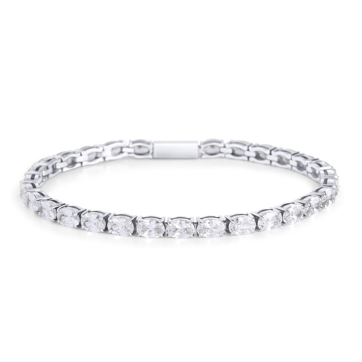 A silver tennis bracelet set with a continuous row of oval clear stones, shown on a clean white background. Waterproof, stainless steel and allergy free. By MIAJWL.
Bracelet tennis argenté serti d'une rangée continue de pierres transparentes ovales, présenté sur fond blanc épuré. Résistant à l'eau, en acier inoxydable et hypoallergénique. Par MIAJWL.