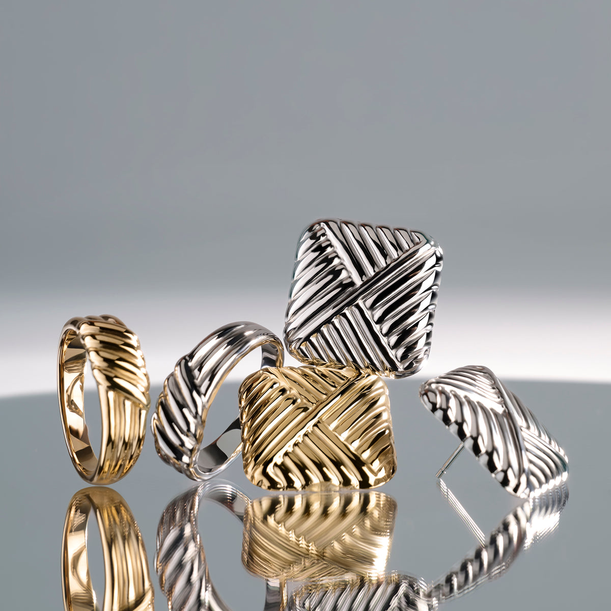 Gold and silver stainless steel textured jewelry set with sculptural rings and stud earrings, woven modern design, hypoallergenic non-tarnish durable jewelry, bold contemporary fashion jewelry.

